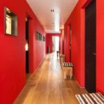 Saténový strop v matnom bielom prevedení s bodovým LED osvetlením v červenej chodbe