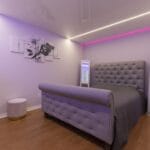 Saténový strop v prevedení matná biela s lineárnym osvetlením v modernej spálni