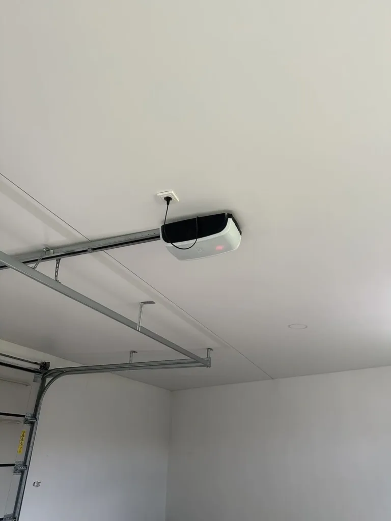 Biely napínací strop s matným finišom inštalovaným nad garážovou bránou