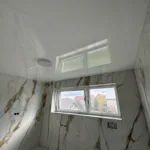 Sprchový kút s nainštalovaný bielym lesklým napínacím stropom