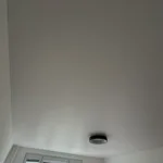 Detail podhľadu s inštalovaným bielym, matným napínacím stropom s prisadeným svietidlom