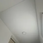 Matný biely napínaný strop s jednoduchým prisadeným stropným svietidlom