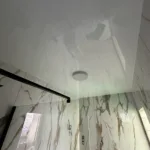 Detailnejší pohľad na napínací strop s jedným svietidlom v mramorovej kúpeľni