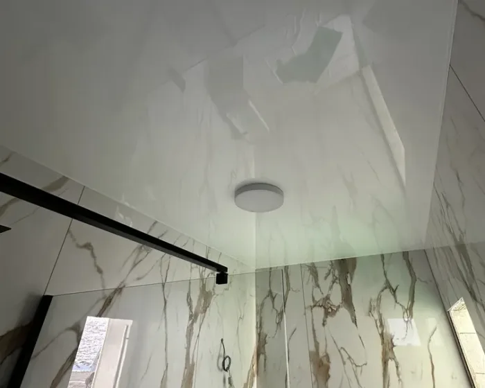 Detailnejší pohľad na napínací strop s jedným svietidlom v mramorovej kúpeľni