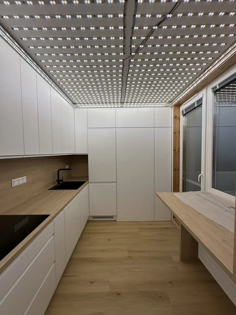 Proces inštalácie svetelného stropu v modernej kuchyni bytu