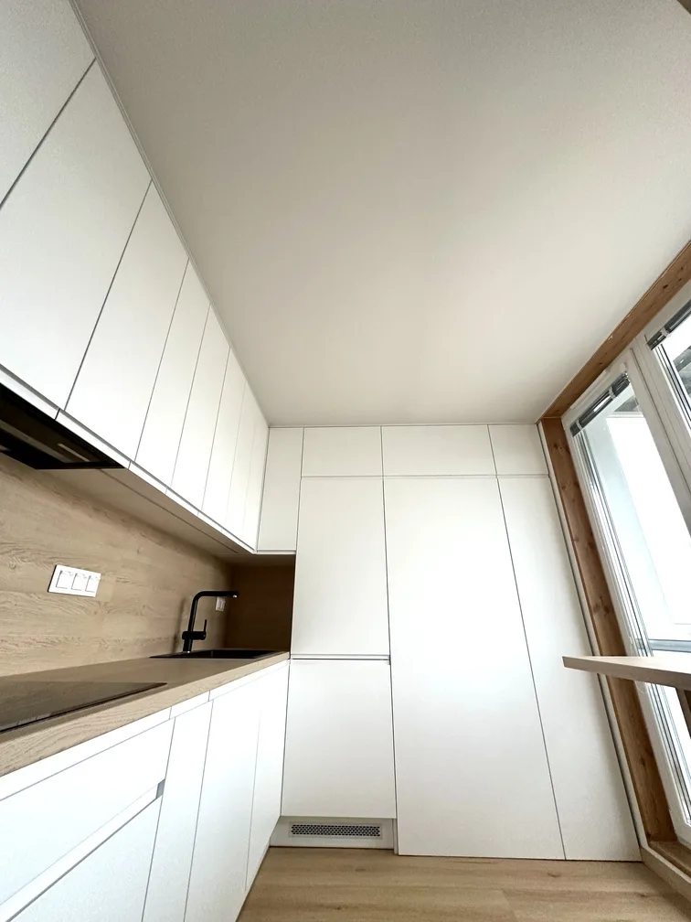 Kuchyňa v modernom dizajnovom byte s detailným pohľadom na svetelný strop cez deň