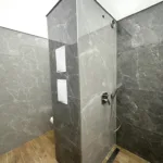 Pohľad na sprchový kút v modernej kúpeľni s nainštalovaným svetelným stropom