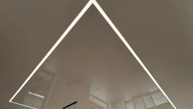 Biely napínaný strop s trojuholníkovým lineárnym LED osvetlením v obývacej izbe